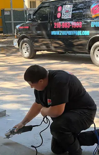 210 Epoxy Pros crew member prepping concrete beside the company truck